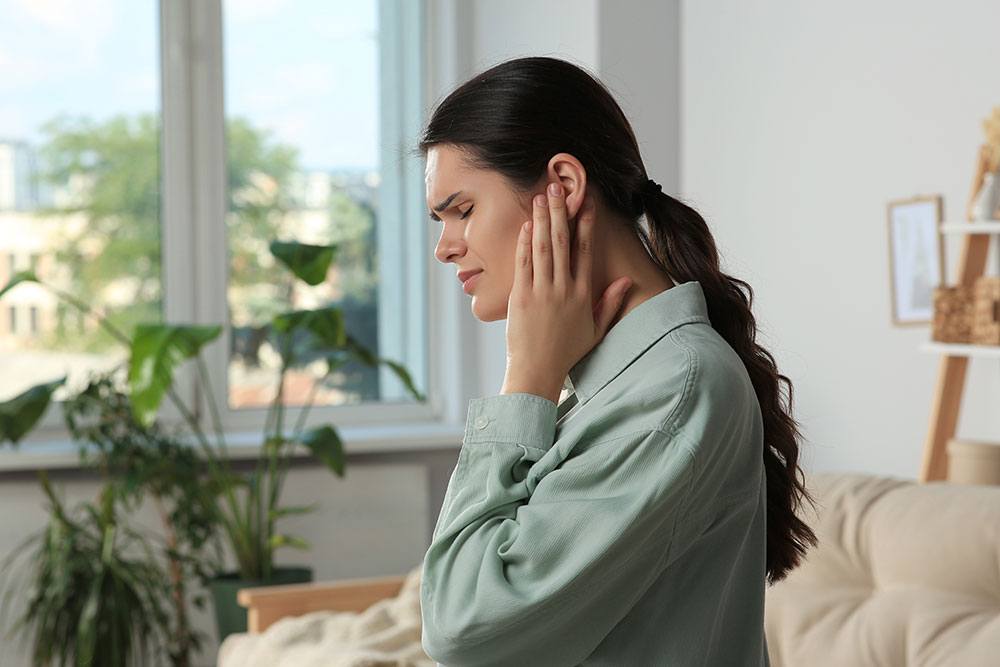 Woman with sore ear, potential ear injury